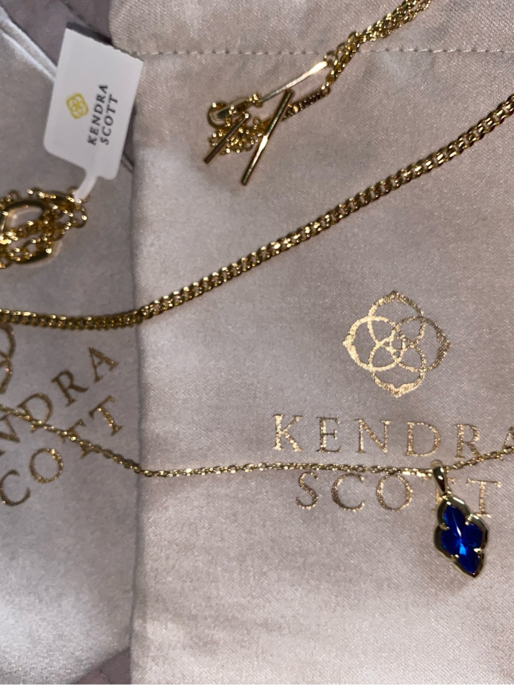 Kendra Scott Gold Necklace with Deep Blue Pendant with matching earrings.